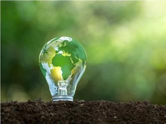 Lightbulb in soil with the world pictured on it